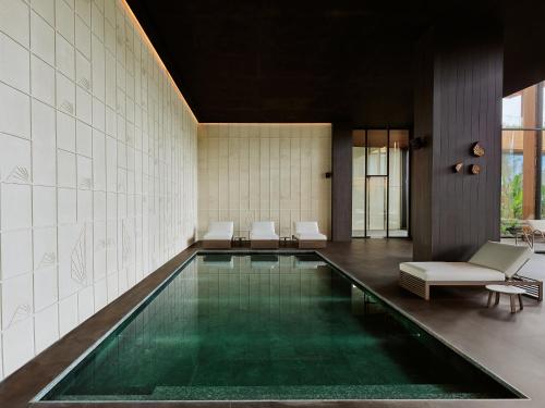 a swimming pool in a room with white tiles at Maxx Royal Bodrum in Bodrum City