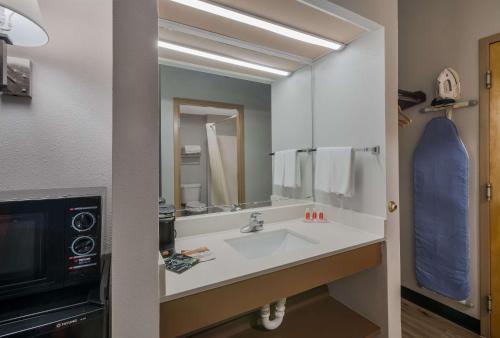 a bathroom with a sink and a large mirror at Econo Lodge Inn & Suites Diamondhead in Diamondhead