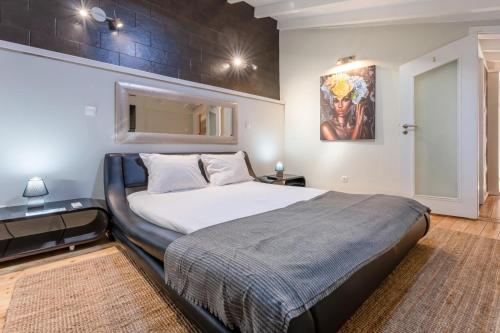 a bedroom with a large bed with a large painting on the wall at Casa 42 - Cozy & Fancy Boutique House in Barão de São João