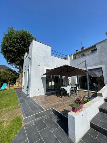 une maison avec une terrasse en bois et un parasol dans l'établissement Chambres privées proche de Versailles, à Fontenay-le-Fleury