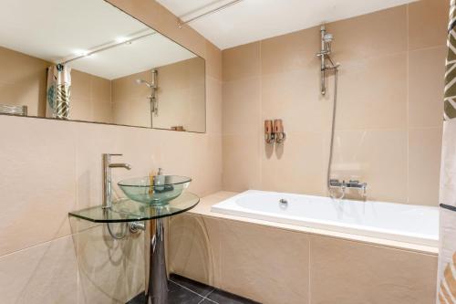 a bathroom with a glass table and a bath tub at Casa 42 - Cozy & Fancy Boutique House in Barão de São João