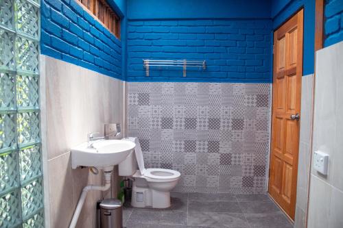 a bathroom with a toilet and a sink and blue walls at The Dusun in Seremban