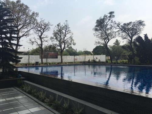 a large swimming pool with a fence around it at Spacious Studio The Edge Bandung Apartment By Travelio in Bandung