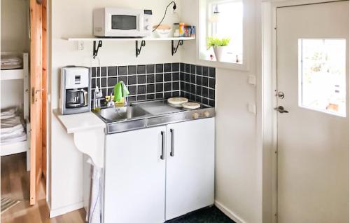 a small kitchen with a sink and a microwave at Gorgeous Apartment In Tjurkö in Sturkö