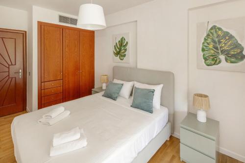 a bedroom with a large white bed with blue pillows at Holiday Maisonette in Varkiza by GHH in Vari