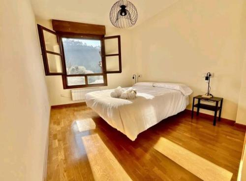 Un dormitorio con una cama grande y una ventana. en La Casina de Noah en Soto de Luiña 304A, en Cudillero