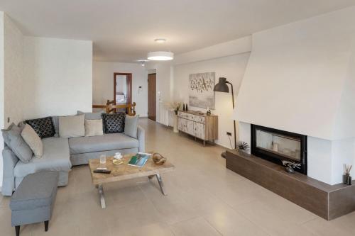 a living room with a couch and a fireplace at Holiday Maisonette in Varkiza by GHH in Vari