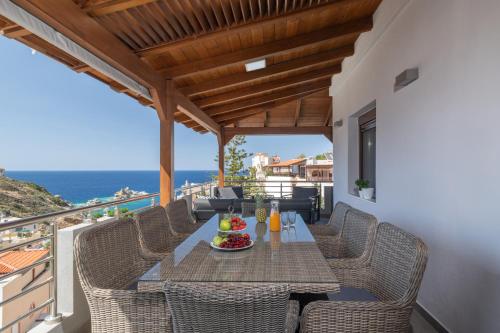 a table and chairs on the balcony of a house at D&A View Luxury Villa 60meters from the Sea in Lygaria