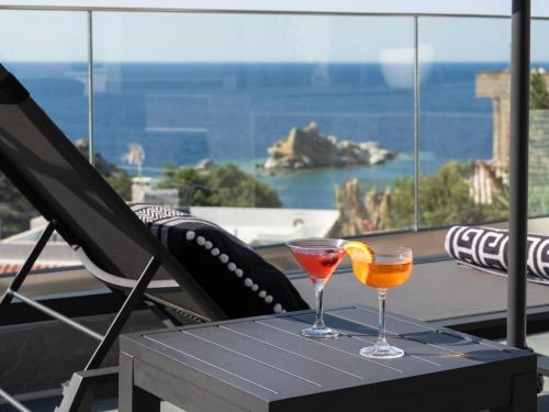 two glasses on a table with a view of the ocean at D&A View Luxury Villa 60meters from the Sea in Lygaria