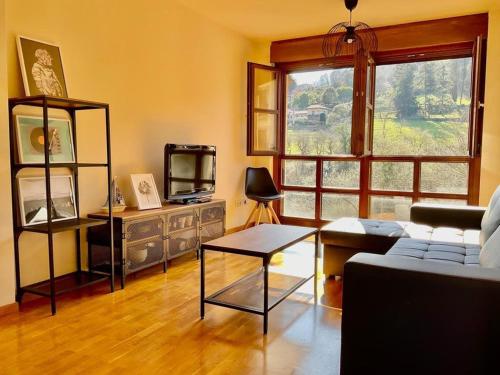 a living room with a couch and a tv at La Casina de Noah en Soto de Luiña 304A in Cudillero