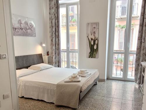 a white bedroom with a bed with towels on it at Affittacamere Guesthouse Maristella in Cagliari