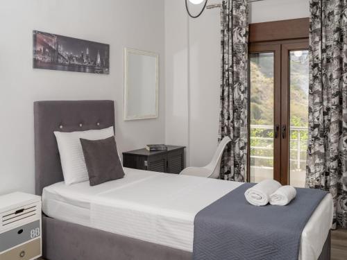 a bedroom with a bed and a desk and a window at D&A View Luxury Villa 60meters from the Sea in Lygaria
