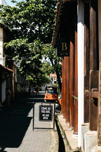 a sign that says give as you are were on a street at The Bungalow Galle Fort - Hotel - Restaurant - Cocktail bar in Galle