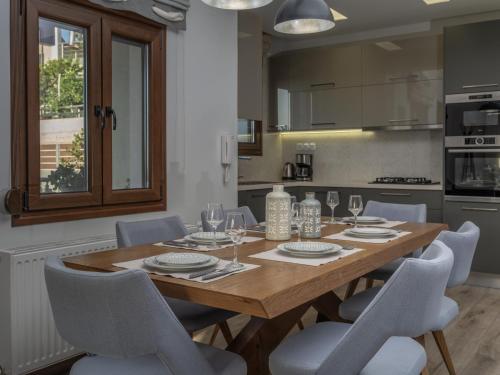 a dining room with a wooden table and chairs at D&A View Luxury Villa 60meters from the Sea in Lygaria