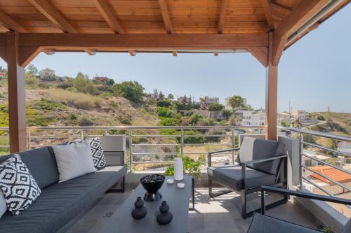 a living room with a couch and chairs on a balcony at D&A View Luxury Villa 60meters from the Sea in Lygaria
