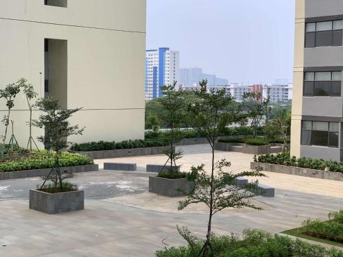 a courtyard with two trees in a building at Good and Modern 2BR Daan Mogot City Apartment By Travelio in Jakarta