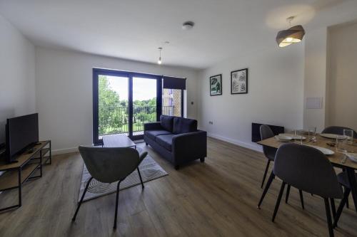 a living room with a couch and a table with chairs at Lovely 2 Bedroom Apartment in Central Ashford in Ashford