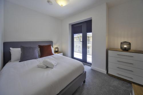 a bedroom with a large white bed and a window at Lovely 2 Bedroom Apartment in Central Ashford in Ashford