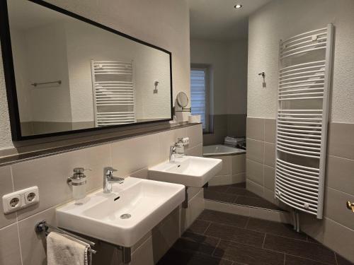 a bathroom with two sinks and a mirror at Ferienwohnung An der alten Stadtmauer in Annaberg-Buchholz