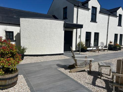 a wooden bench sitting in front of a building at Bayview Farm Holiday Cottages in Bushmills