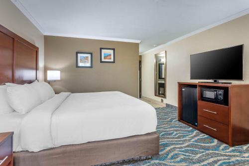 a hotel room with a bed and a flat screen tv at Comfort Inn Asheville East-Blue Ridge Pkwy Access in Asheville