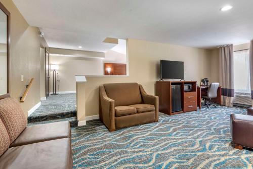 a hotel room with a chair and a television at Comfort Inn Asheville East-Blue Ridge Pkwy Access in Asheville