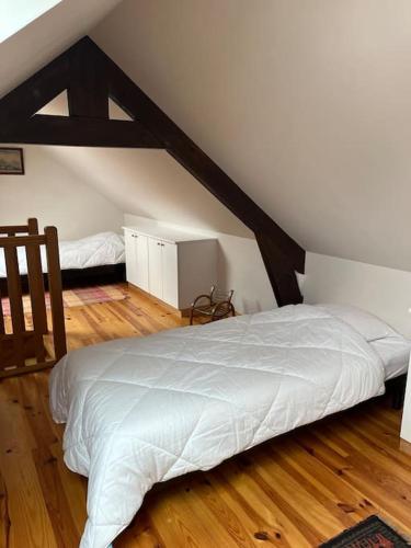 une chambre avec un lit blanc dans un grenier dans l'établissement Ty Ker-sa classé 2 étoiles, à Ploubazlanec