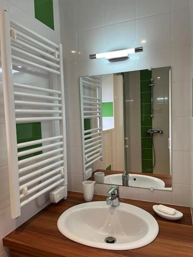 une salle de bain avec un lavabo, un miroir et une baignoire dans l'établissement Ty Ker-sa classé 2 étoiles, à Ploubazlanec