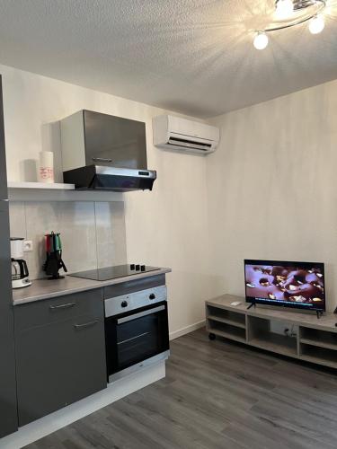 Il comprend une cuisine équipée d'une cuisinière et une télévision. dans l'établissement Studio à 100m de la mer, au Cap d'Agde