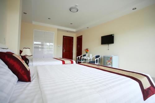 a bedroom with a large white bed and a tv at Sun & Sea Hotel in Phu Quoc