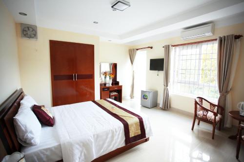 a bedroom with a bed and a desk and a window at Sun & Sea Hotel in Phu Quoc