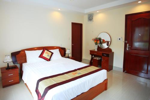a bedroom with a large bed and a mirror at Sun & Sea Hotel in Phu Quoc