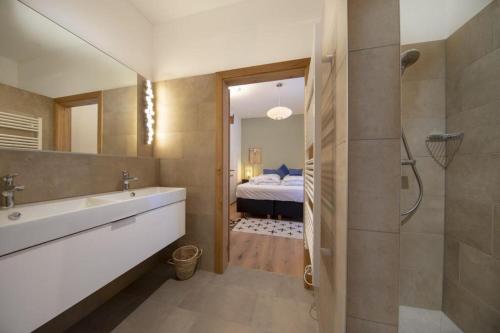 a bathroom with a tub and a sink and a bed at Edelweisshaus Top 5 in Königsleiten