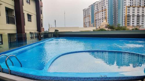 a large blue swimming pool on top of a building at Homey and Comfort Stay Studio Atria Residences Gading Serpong Apartment By Travelio in Tangerang