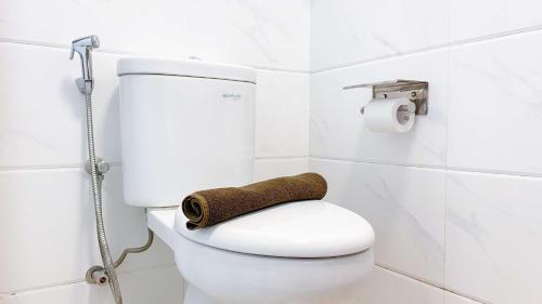 ein Badezimmer mit einem WC und einem Handtuch auf dem Sitz in der Unterkunft Best Choice and Nice Studio at Sky House BSD Apartment By Travelio in Tangerang