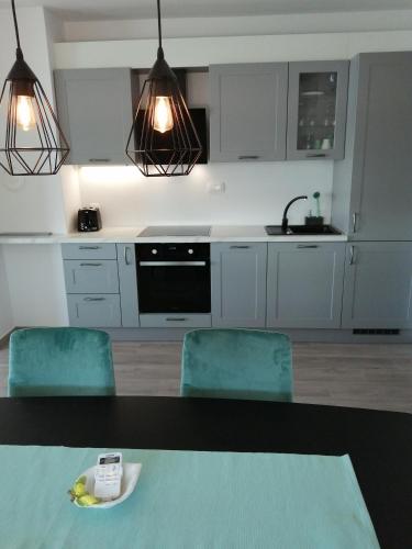 a kitchen with a table and two green chairs at SMARAGD on the beach in Povljana