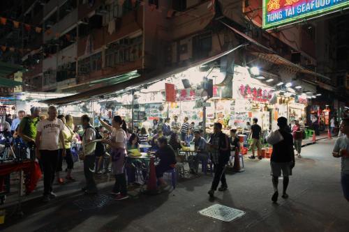 a group of people walking around a street in a market at Shanghai Red in Hong Kong