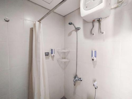 a bathroom with a shower with a shower curtain at Strategic and Comfy Studio at Skyland City Jatinangor Apartment By Travelio in Sumedang