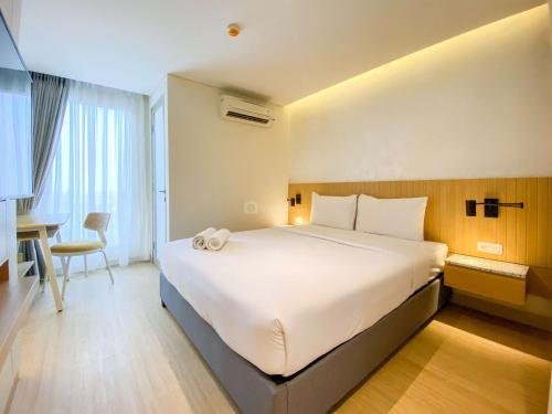 a bedroom with a large white bed in a room at Best Deal and Strategic 2BR Marquis de Lafayette Apartment By Travelio in Semarang