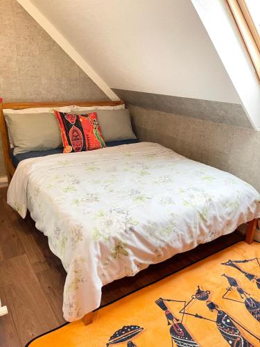 a bed sitting in a room with a window at Crescent Loft Apartment - 1 bed in Goodmayes