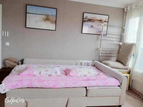 - une chambre avec un lit rose et une chaise dans l'établissement Chevaleret-Paris, à Paris