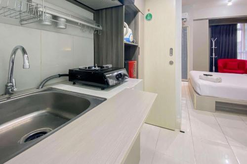 Una cocina con un fregadero y una tostadora en la encimera. en Comfortable 1BR without Living Room at Amartha View Apartment By Travelio, en Semarang