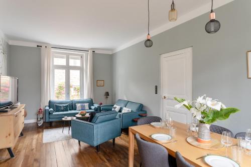 un salon avec des chaises bleues et une table dans l'établissement Villa le Moulin sans souci - Maison à Saint-Malo, à Saint-Malo