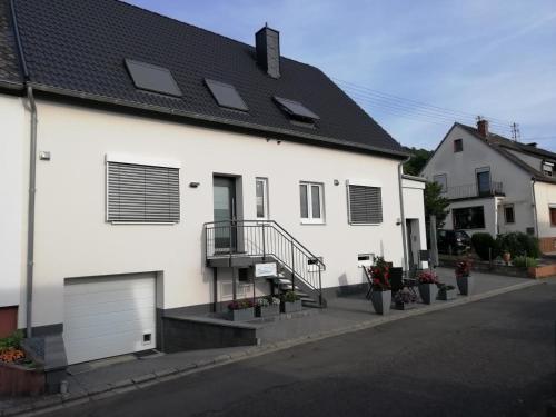 a white house with solar panels on the roof at Ferienwohnung Alexandra in Wintrich in Wintrich