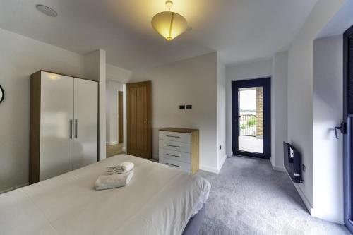 a bedroom with a large white bed and a dresser at Stunning 2 Bedroom Apartment in Central Ashford in Ashford