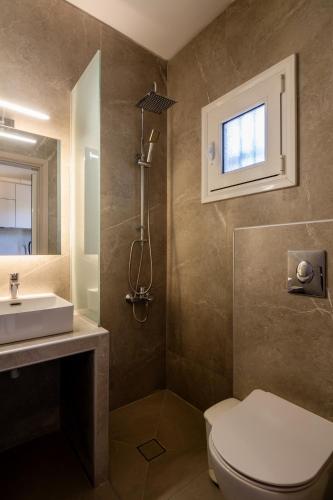 a bathroom with a toilet and a sink and a window at Garden House in Velika