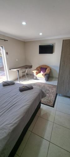 a bedroom with a large bed and a couch at First 2 Stay in Germiston