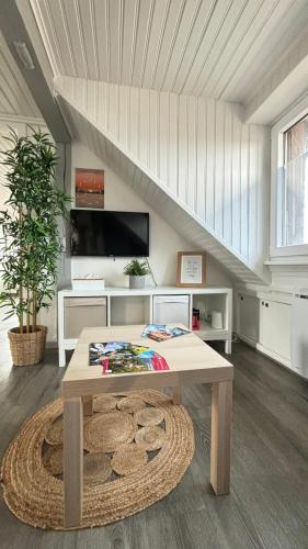 un salon avec une table et un escalier dans l'établissement Le Nid de Maria, à Hilsenheim