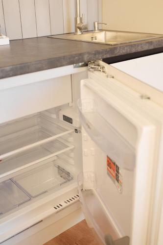 an empty refrigerator with its door open in a kitchen at Apart Hotel Acropolis in Odesa