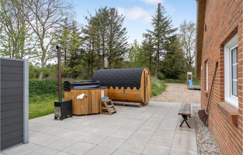 Un patio con una gran parrilla al lado de un edificio. en Lovely Home In Ulfborg With Sauna, en Ulfborg